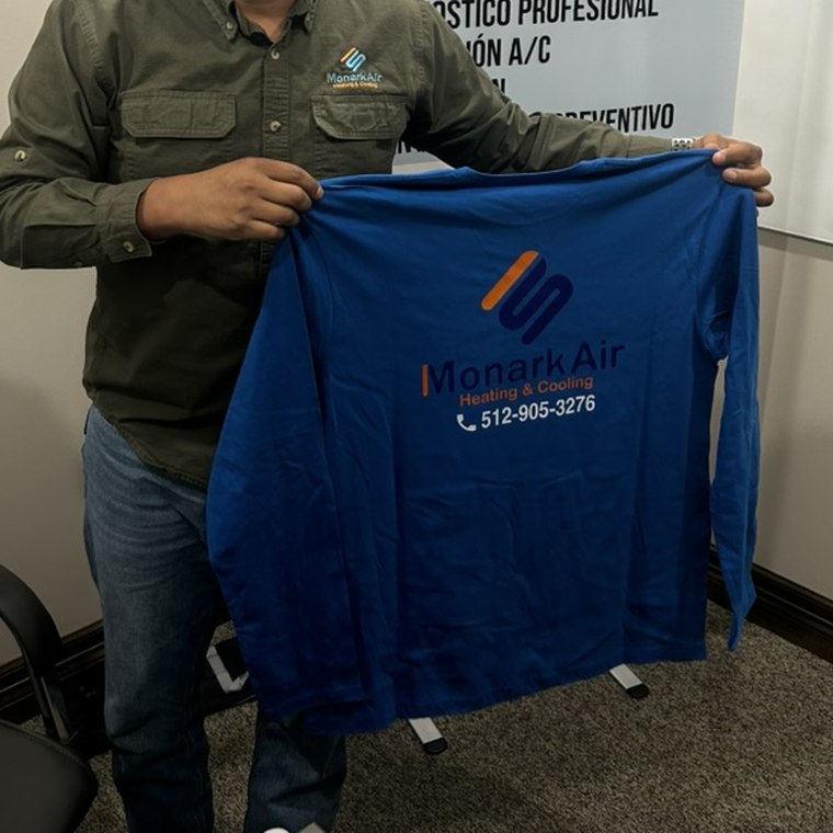 Monark Air work shirt with the company logo and phone number
